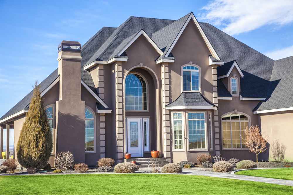 large home with asphalt shingles and a grass front yard
