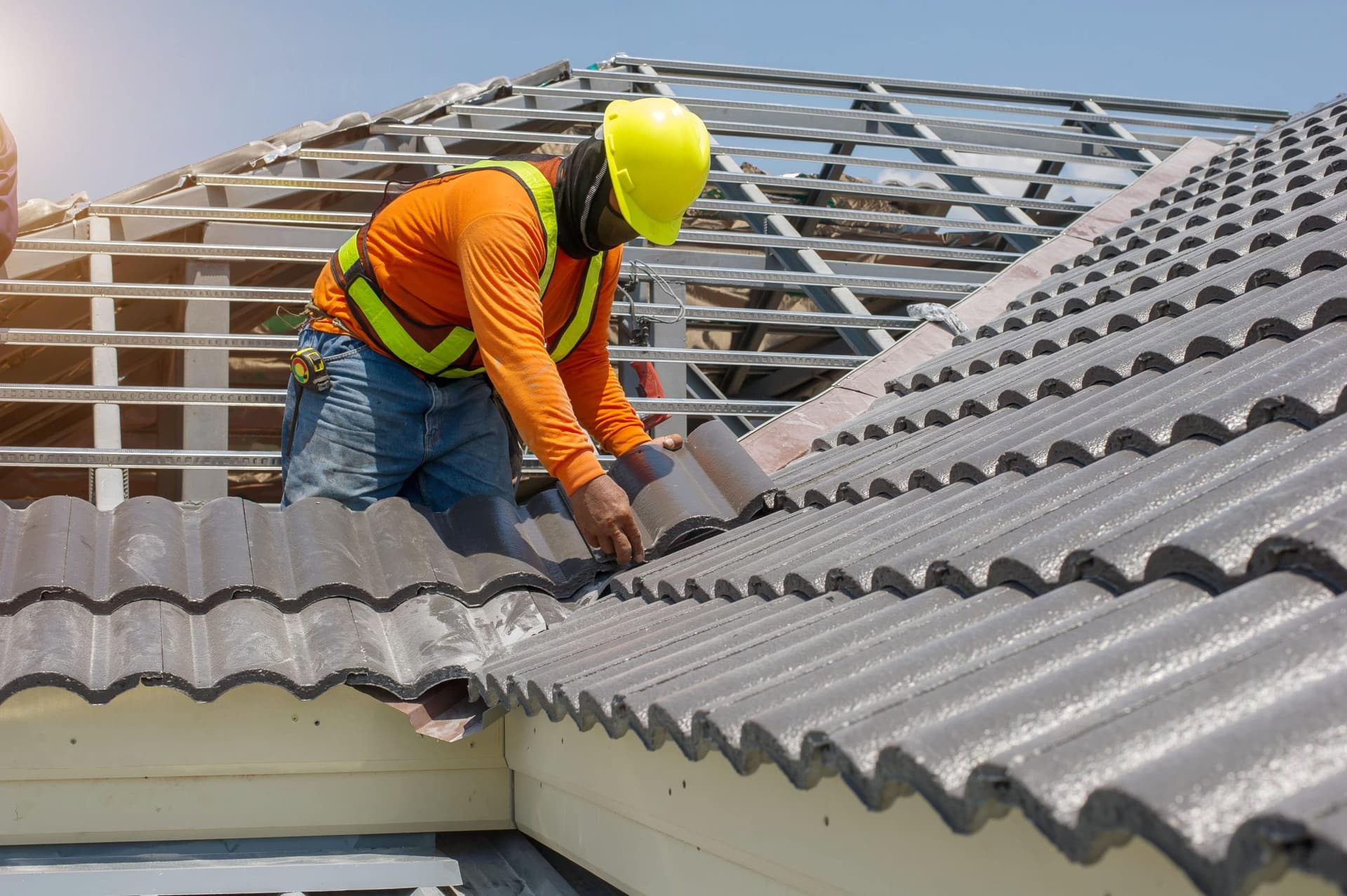 roofing tech on tile roof doing roof replacement