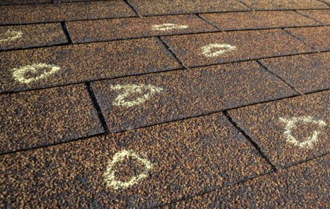 chalk marks on a hail-damaged shingle roof