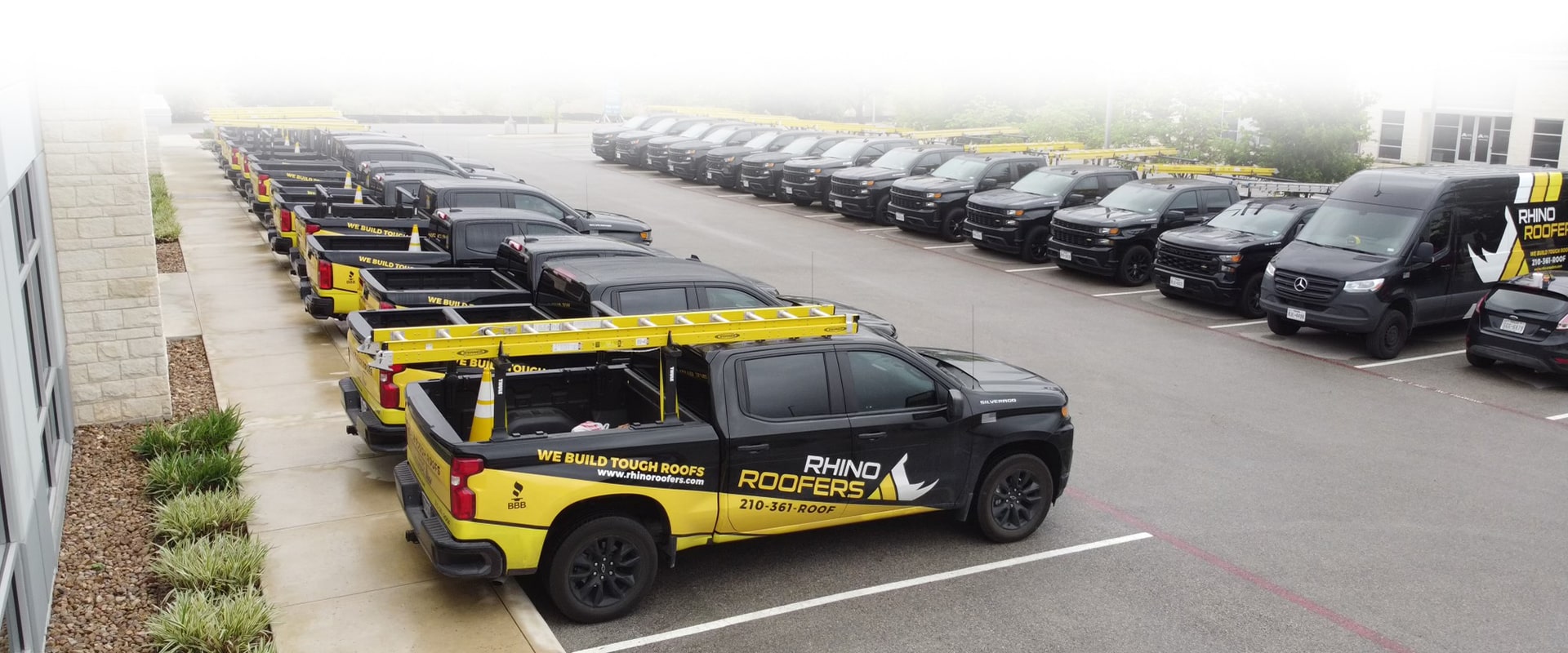 Rhino Roofers fleet of branded trucks lined up in San Antonio