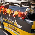 Rhino Roofers table decorated with pumpkins, leaves, and festive fall accents at the Kinetic Kids Halloween community event.