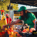 Rhino Roofers booth with Luigi costume and branded signage during the Kinetic Kids Halloween Family Unite Night in Helotes.
