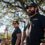 Rhino Roofers team members smiling and welcoming families at the Kinetic Kids Halloween community event in Helotes, Texas.