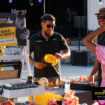 Rhino Roofers team members smiling and talking with families at the Kinetic Kids Halloween Family Unite Night community event.