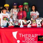 Therapy 2000 team dressed as Mario Bros characters at their booth during the Kinetic Kids Halloween community event in Helotes.