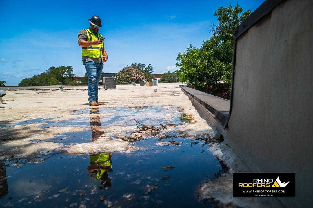 Standing water and debris documented during a commercial roof inspection in San Antonio